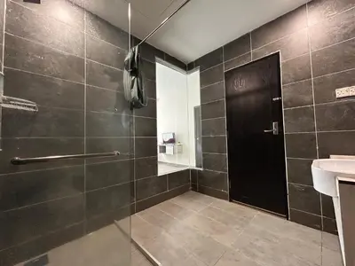 a bathroom with a glass shower door and a sink at Kingston Hotel by Minsu in Kuala Lumpur