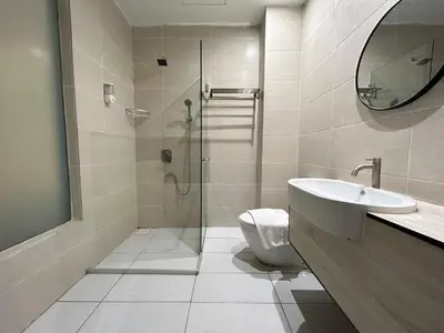 a bathroom with a shower and a toilet and a sink at Kingston Hotel by Minsu in Kuala Lumpur