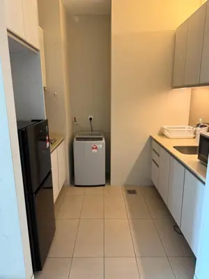 a small kitchen with a refrigerator and a sink at Swiss Garden Residences by Roomy in Kuala Lumpur