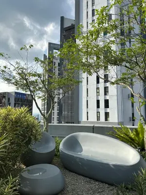 two benches sitting next to some trees and buildings at The Mews Suites KLCC By Luna in Kuala Lumpur