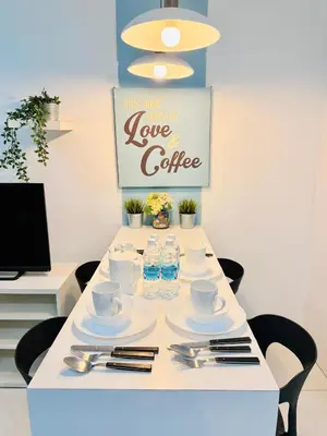 a table with cups and saucers and water bottles at Mercu Summer Suites KLCC By Suite Apartment in Kuala Lumpur