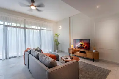 a living room with a couch and a tv at Embassy Villa by Cobnb at Ampang Hilir in Kuala Lumpur