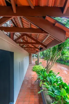 a patio under a wooden roof with plants at Embassy Villa by Cobnb at Ampang Hilir in Kuala Lumpur