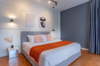 a bedroom with a large bed with an orange blanket at Embassy Villa by Cobnb at Ampang Hilir in Kuala Lumpur