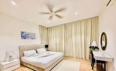 a white bedroom with a bed and a desk at Majestic Suites KLCC in Kuala Lumpur
