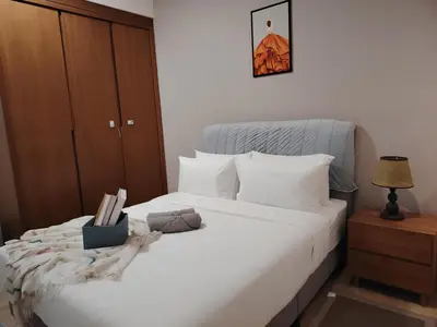 a bedroom with a white bed with a wooden cabinet at Agile Residence Dual-Key Gem Bukit Bintang by Natol Chain of Homestays in Kuala Lumpur