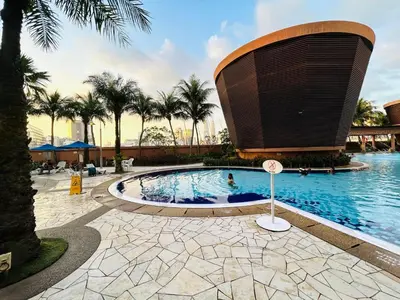 a swimming pool in front of a building with palm trees at PERFECT SUITE at TIMES SQUARE KL in Kuala Lumpur