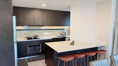 a kitchen with a counter and some brown cabinets at The Atrium at Jalan Ampang by OKBnB - Classy Executive Family Suite 3Bedroom with Balcony , nearby KLCC in Kuala Lumpur