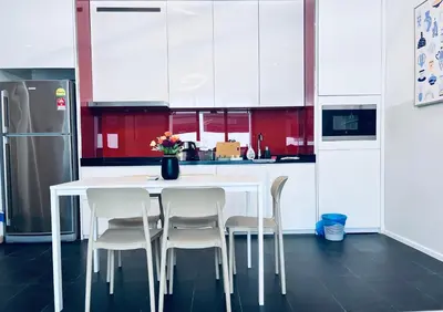 a kitchen with a white table and white chairs at Arcoris SOHO by Cj in Kuala Lumpur