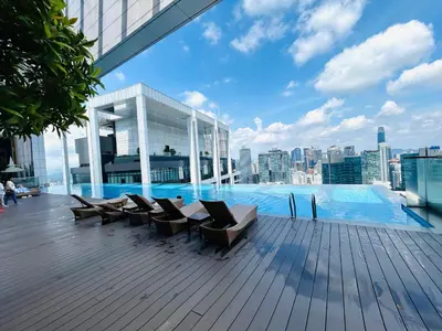a deck with chairs and a swimming pool on a building at PLATINUM SUITE by KUALALUMPUR MALAYSIA in Kuala Lumpur