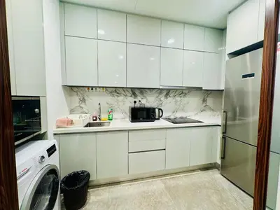 a kitchen with white cabinets and a sink and a refrigerator at PLATINUM SUITE by KUALALUMPUR MALAYSIA in Kuala Lumpur
