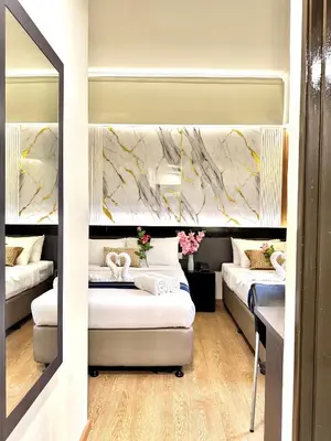 a hotel room with two beds and a mirror at Central City Hotel at Chinatown in Kuala Lumpur