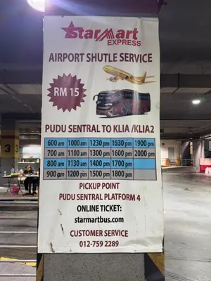 a sign for an airport shuttle service in a parking garage at Central City Hotel at Chinatown in Kuala Lumpur