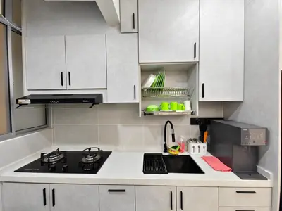 a kitchen with white cabinets and a sink and a stove at Aiman Damia Homestay in Kuala Lumpur