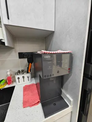 a small kitchen with a microwave and a red rug at Aiman Damia Homestay in Kuala Lumpur