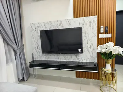 a living room with a tv on a wall at AimanDamia Homestay Setapak II in Kuala Lumpur