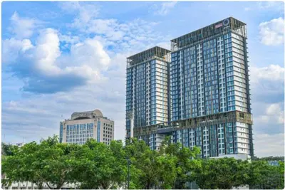 two tall buildings in a city with trees in front at Opus Residence by Cloud Escape in Kuala Lumpur