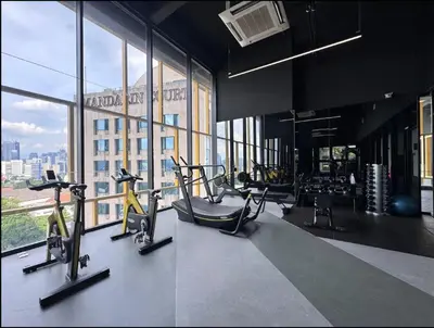 a gym with cardio equipment in a building with windows at Opus Residence by Cloud Escape in Kuala Lumpur
