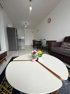 a living room with a white table with flowers on it at Cozy kenwingston platz kl 2-5pax 2BR&2BR Klcc view with free parkin 4305 in Kuala Lumpur