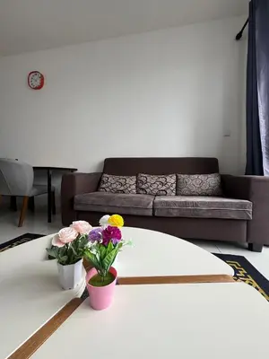 a living room with a couch and flowers on a table at Cozy kenwingston platz kl 2-5pax 2BR&2BR Klcc view with free parkin 4305 in Kuala Lumpur