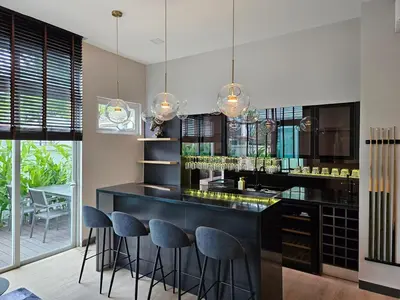 a kitchen with a black counter and stools at Villa Homescape, Mont Kiara in Kuala Lumpur