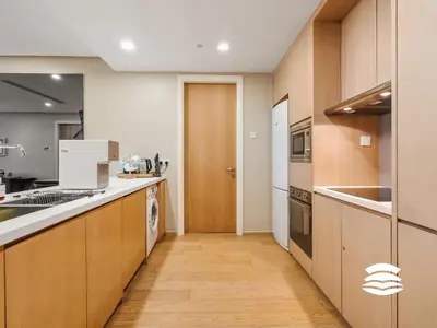a kitchen with wooden cabinets and a counter top at 188 Suites KLCC by Soulasia in Kuala Lumpur
