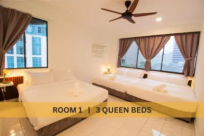 two beds in a hotel room with windows at Downtown Condo KL City - 18 pax in Kuala Lumpur