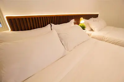 a bedroom with two beds with white pillows at Downtown Condo KL City - 18 pax in Kuala Lumpur