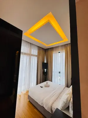 a bedroom with a large bed with a yellow ceiling at Dorsett Suites Kuala Lumpur By AFA in Kuala Lumpur