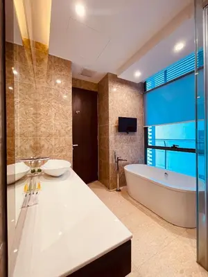 a bathroom with two sinks and a tub and a television at Dorsett Suites Kuala Lumpur By AFA in Kuala Lumpur