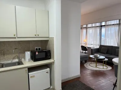 a kitchen and living room with a couch and a microwave at Times Residence At BTS Kuala Lumpur in Kuala Lumpur