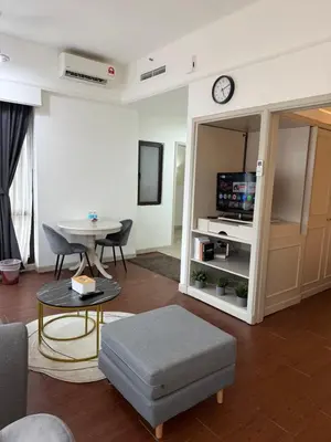a living room with a table and a tv at Times Residence At BTS Kuala Lumpur in Kuala Lumpur