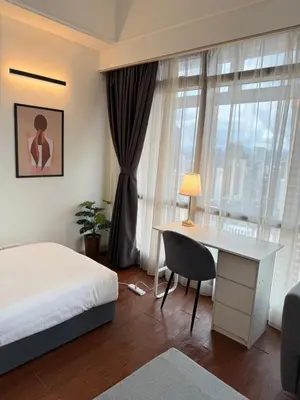 a bedroom with a bed and a desk and a window at Times Residence At BTS Kuala Lumpur in Kuala Lumpur