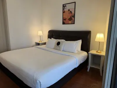 a bedroom with a large white bed with two lamps at Times Residence At BTS Kuala Lumpur in Kuala Lumpur