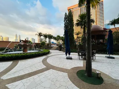 a courtyard with a fountain and palm trees in a city at Times Square by Perfect in Kuala Lumpur