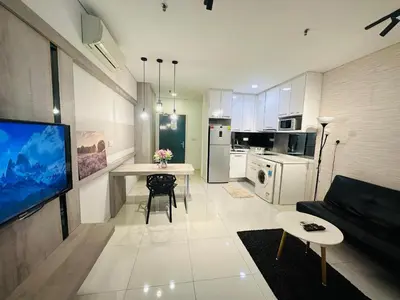 a living room with a couch and a table and a tv at Summer Hotel and Condo Suites Nearby KLCC Area in Kuala Lumpur