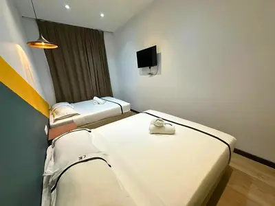 a hotel room with two beds and a flat screen tv at Seeds Hotel Bukit Bintang in Kuala Lumpur
