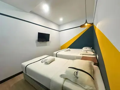 two beds in a small room with a tv at Seeds Hotel Bukit Bintang in Kuala Lumpur