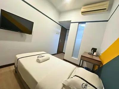 a small room with a bed and a television at Seeds Hotel Bukit Bintang in Kuala Lumpur