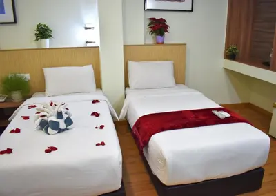 two beds in a room with roses on them at Xpeed Holiday Hotel in Kuala Lumpur
