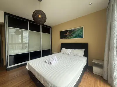 a bedroom with a large bed with white sheets at The Ohana Suite in Kuala Lumpur
