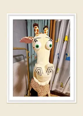 a stuffed giraffe is sitting on a bed at Bintang Nyonya Villa-A self designed Home in Kuala Lumpur