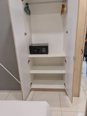 a white closet with a clock on a shelf at Robertson Residence Main City Kuala Lumpur in Kuala Lumpur