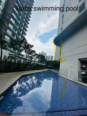 a blue swimming pool next to a building at Robertson Residence Main City Kuala Lumpur in Kuala Lumpur