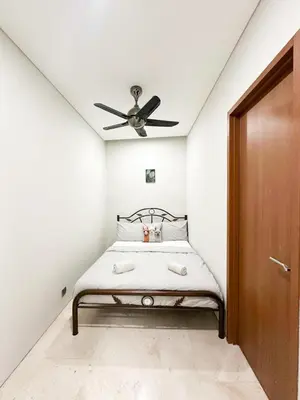 a bedroom with a bed with a ceiling fan at Modern Condo Next To Petronas Towers in Kuala Lumpur