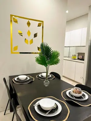 a black table with plates and a plant on it at Modern Condo Next To Petronas Towers in Kuala Lumpur