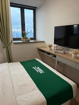 a hotel room with a bed and a desk with a television at Nest Heaven Host in Kuala Lumpur