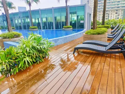 a deck with chairs and a swimming pool on a building at Vortex Premium Apartment klcc in Kuala Lumpur