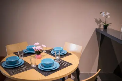a wooden table with blue dishes and flowers on it at Bangsar LRT Suites EST by LSA in Kuala Lumpur