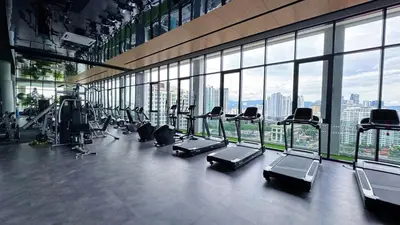 a gym with a row of treadmills and machines at The Thant Suite in Kuala Lumpur